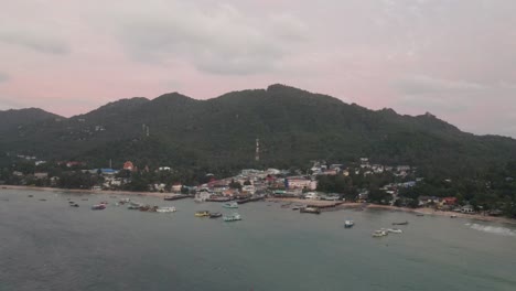 Vista-Aérea-Sobre-El-Muelle-De-Koh-Tao-Y-La-Isla-Con-Barcos-Amarrados-En-El-Océano