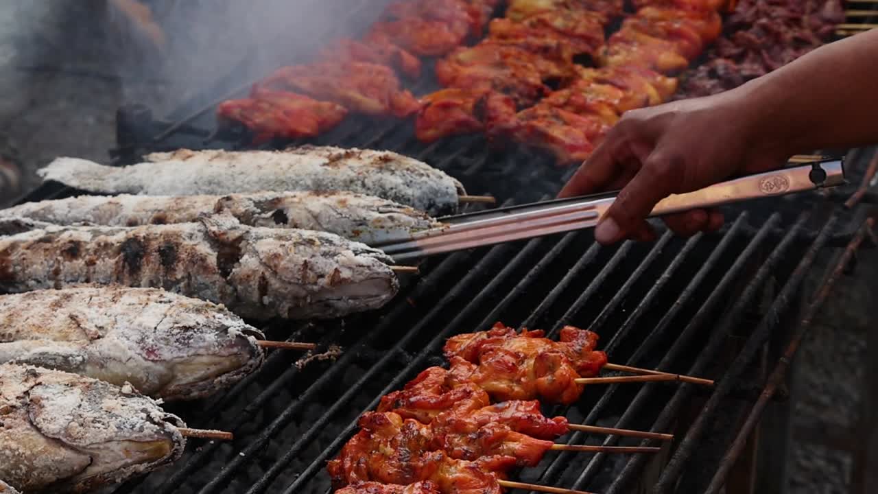 Grilling fish and skewers over charcoal flames.