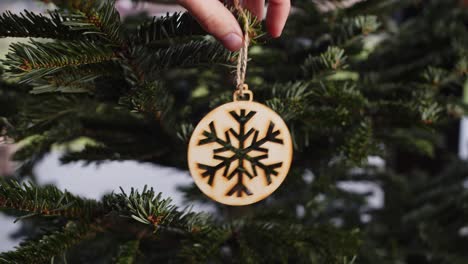 hanging wooden decoration on green christmas tree close up 4k