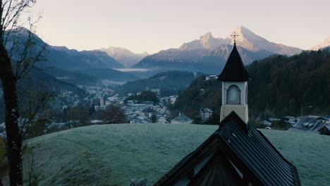 Herbstlandschaft-In-Bayern,-Deutschland-|-4k-Uhd-D-log-–-Kalte,-Neblige-Sonnenaufgangsfarben-über-Berchtesgarden,-Deutschland,-Mit-Einer-Filmischen-Drohnenaufnahme-Einer-Kapelle-Mit-Blick-Auf-Die-Stadt-–-Berge