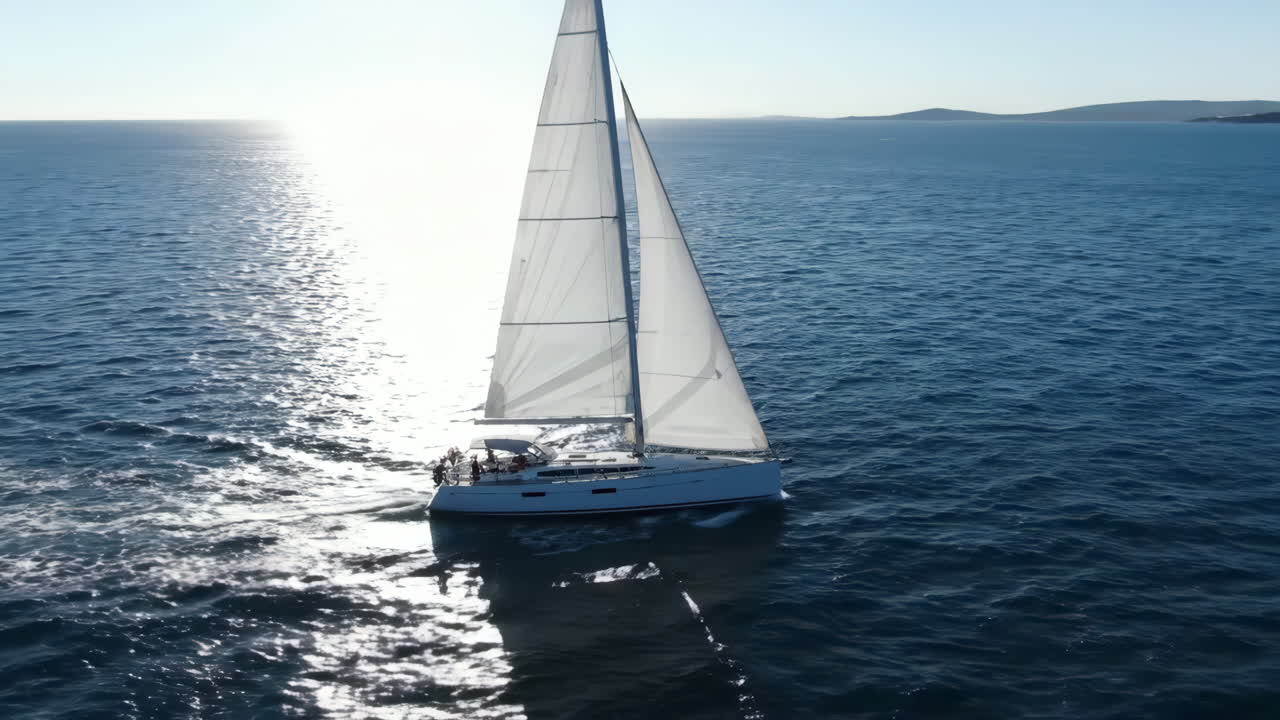 Sailboat cruising on the open ocean with sun reflection