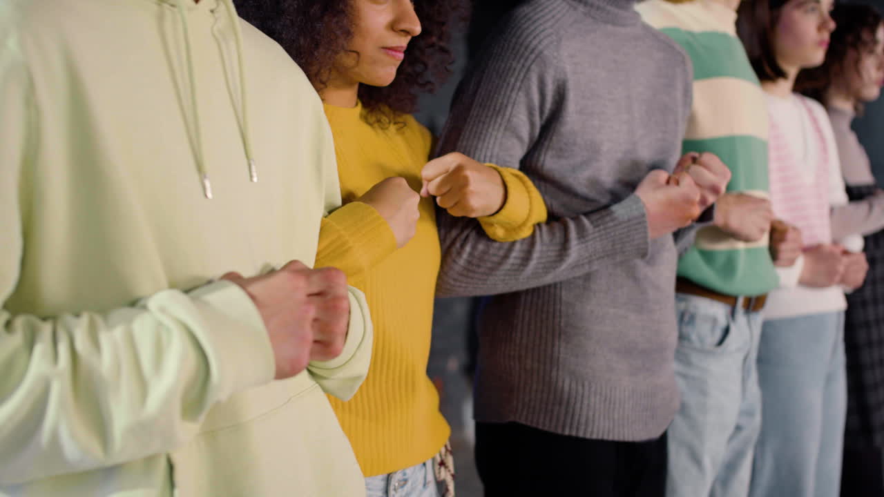 팔을 잠근 채 서있는 장벽을 형성하는 젊은 시위자들의 폐쇄