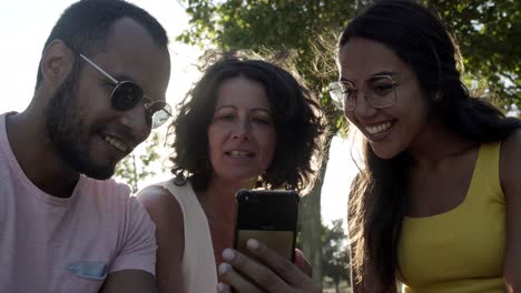 cheerful multiethnic friends with smartphone