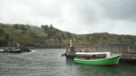 barco verde en el agua - puerto de porto formoso, azores