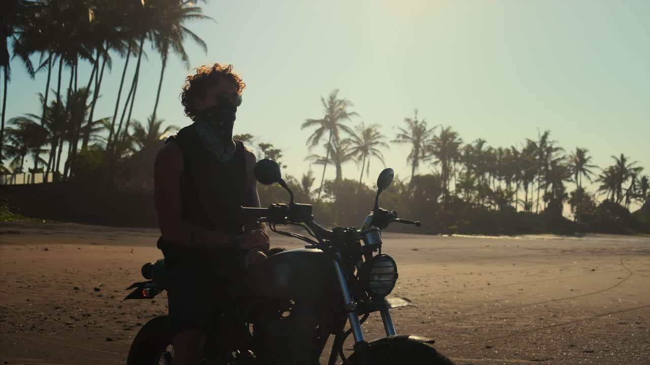 Uomo in moto su spiaggia tropicale