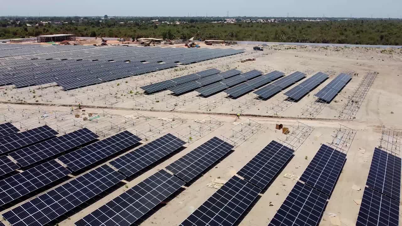 vista aérea de una enorme planta de energía fotovoltaica con paneles solares en construcción en jambur, gambia