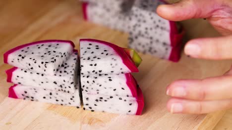 hands slicing dragon fruit into even pieces