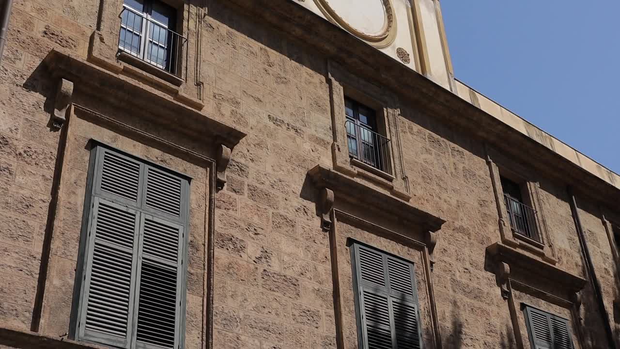 reloj de la ciudad en la pared del edificio de palermo, italia