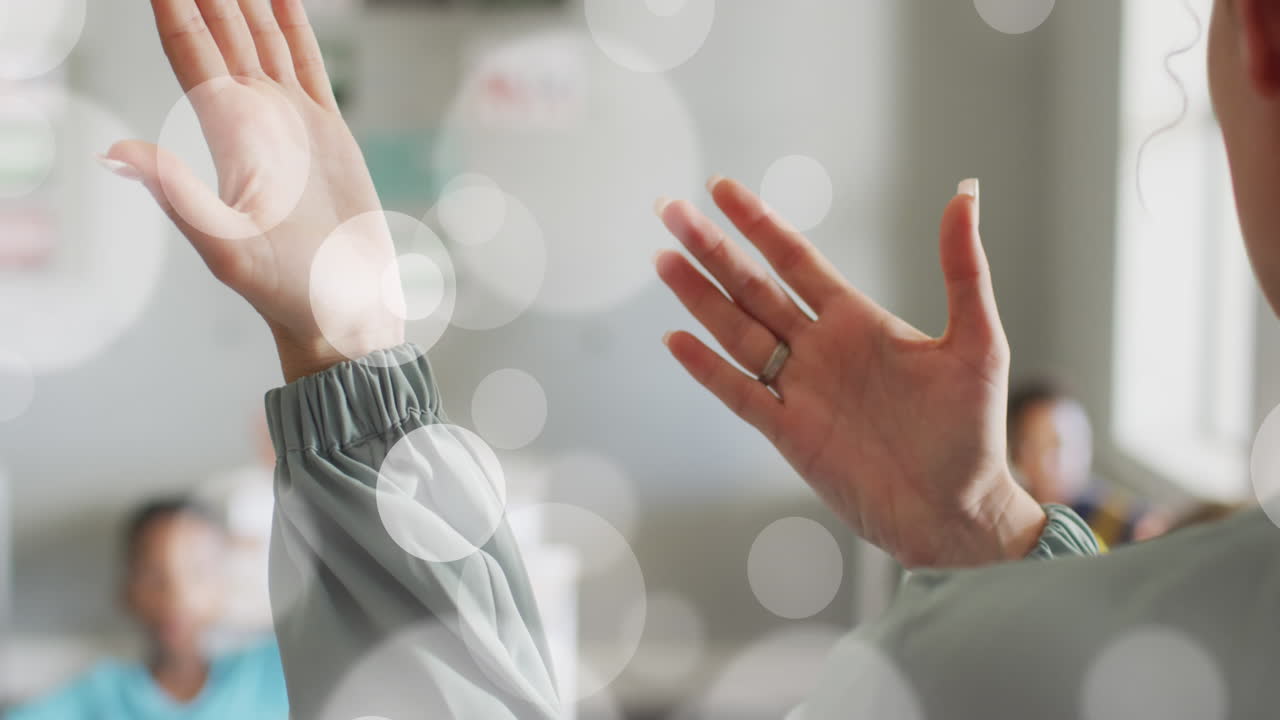 다양한 여성 교사와 학생들의 손 위에 색 보케 스의 애니메이션