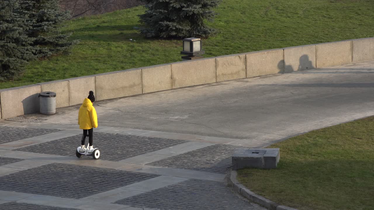 전기 스쿠터를 타는 작은 소녀 . 개인 에코 운송, 자이로 스쿠터, 스마트  ⁇ 런스  ⁇ . 인기 있는 전기 운송