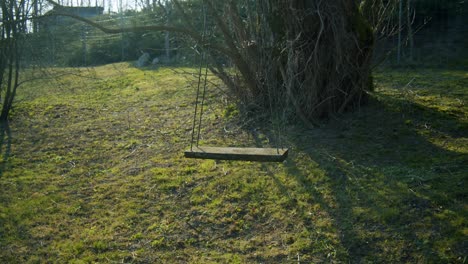 Eine-Selbstgebaute-Holzschaukel-Auf-Einem-Ast-Auf-Den-Feldern-Am-Abend