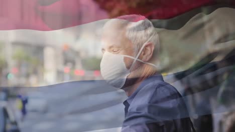 Animation-of-flag-of-netherlands-waving-over-caucasian-man-wearing-face-mask-in-city-street