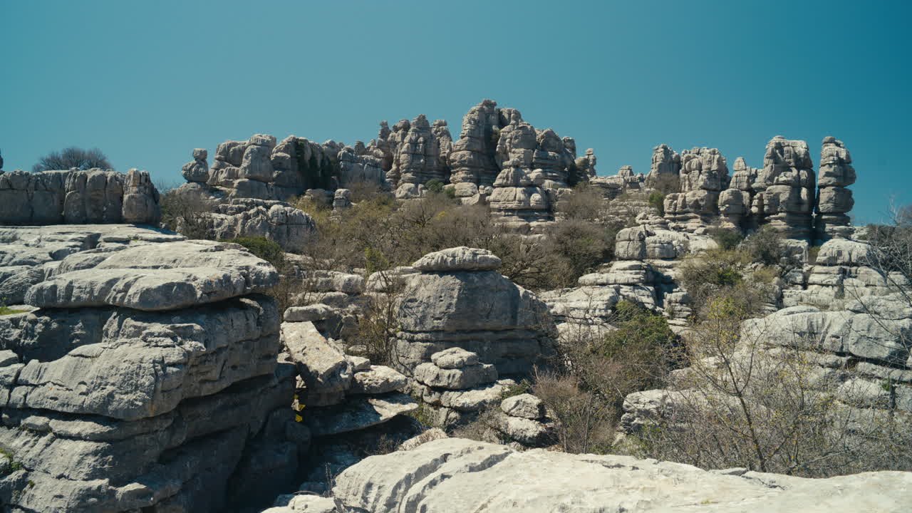 Ampia veduta di spettacolari formazioni calcaree e terreno accidentato a El Torcal de Antequera, Andalusia, Spagna, che mostra un paesaggio carsico unico sotto un cielo azzurro e limpido.