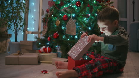 Adorable-Niño-De-Tres-Años-Abriendo-Su-Regalo-De-Navidad-Y-Encontrando-Un-Osito-De-Peluche-Dentro.-Imágenes-4k-De-Alta-Calidad