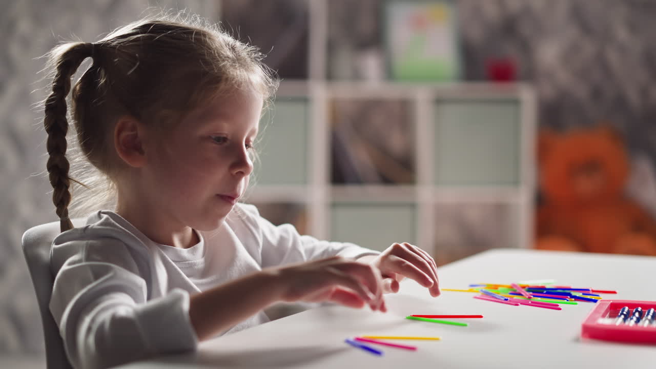 Una bambina si sgranchisce le braccia e tira fuori la lingua, preparandosi per la lezione.