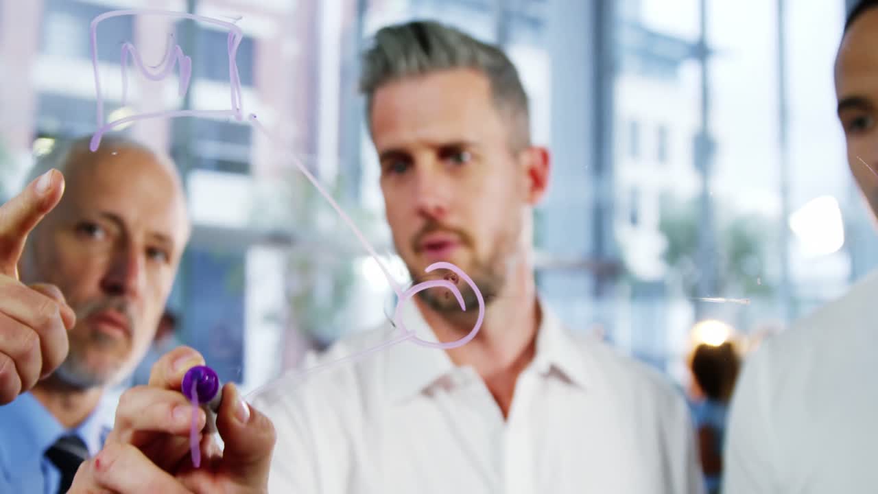 유리 창에 글을 쓰는 동안 이야기하는 비즈니스 동료