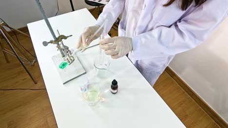 a scientist conducts a chemical reaction between copper carbonate and sulfuric acid in a controlled laboratory setting