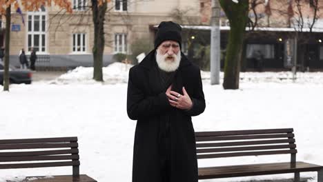 a bearded man enjoys a serene winter day in a snowy landscape a bearded man enjoys a serene winter day in a snowy landscape alternating between standing and sitting on a bench soaking in the tranquility