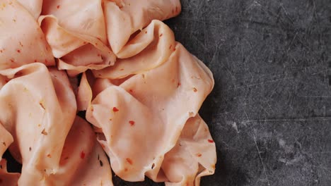 ham italian mordatella, man slices of traditional italian antipasti mortadella sausage on a wooden cutting board, close up macro of chicken or turkey jamon, fat breakfast dish.