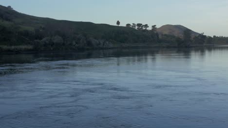 the beautiful and peaceful scenery of a blue calm sea in catlins in new zealand - wide shot