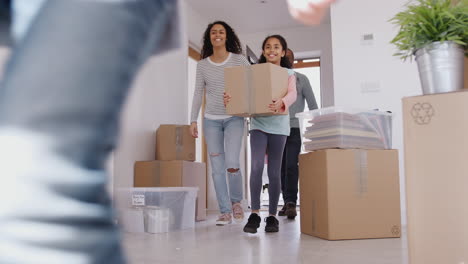 Familia-Sonriente-Llevando-Cajas-A-Su-Nuevo-Hogar-El-Día-De-La-Mudanza