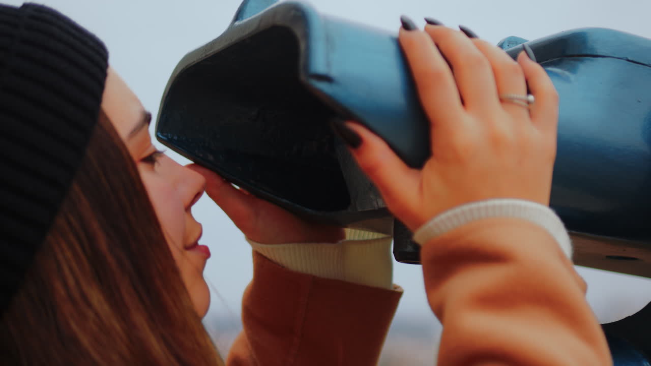 una joven observando la ciudad desde un punto de vista, de cerca.