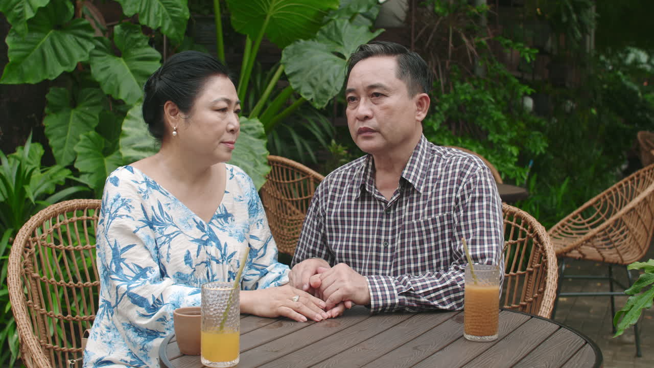 Caring Wife Supporting Sad Mature Husband in Cafe