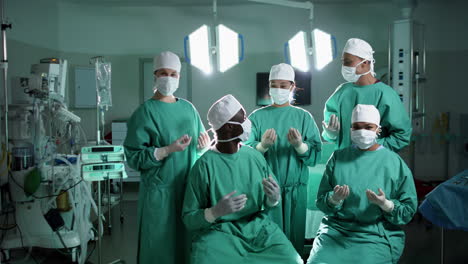 portrait of diverse surgeons wearing surgical gowns in operating theatre, slow motion