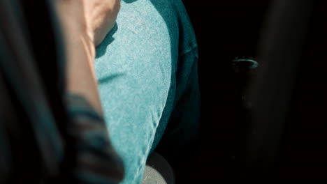 el hombre con el anillo en la mano cambia la marcha de su auto en cámara lenta y el sol se asoma por la ventana