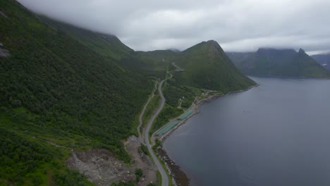 flying over the mountain road towards the old fishing village husoy on senja island