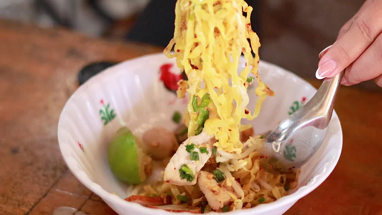 Preparing and enjoying noodles with chopsticks and spoon