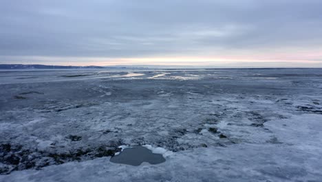 drone flying over the frozen river in baie saint-paul