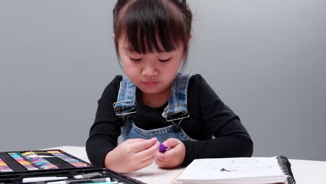 child choosing black pen in the full case for drawing