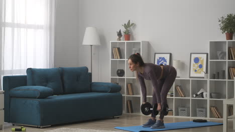 workout-of-woman-with-dumbbells-in-hands-training-in-living-room-at-weekends-healthy-lifestyle-and-wellness-power-training