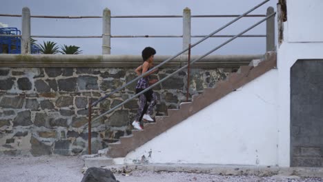 mixed race woman running on staircase on docks