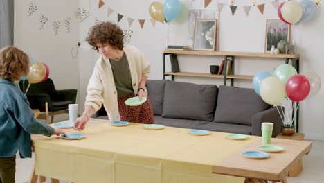 mujer y niño preparando la mesa