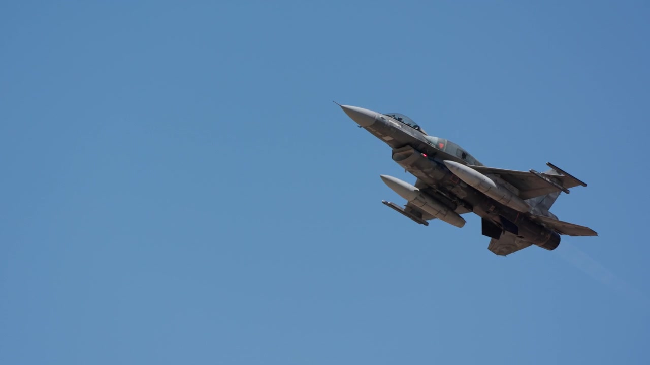 Fighter jet banking away in a climb