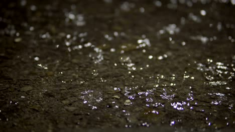 la lluvia cae salpicando el pavimento inundado de asfalto.