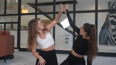 dos mujeres jóvenes divirtiéndose juntas durante una rutina de ejercicio.