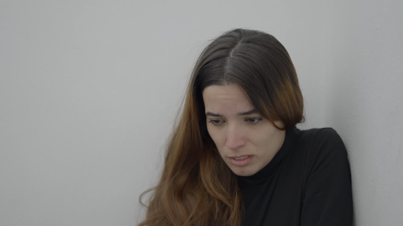 Sad Woman Leaning Against a Wall