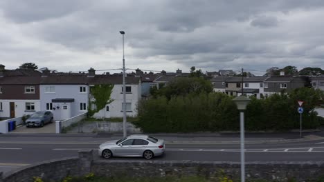 a silver car drives by claddagh, in grattan road, galway