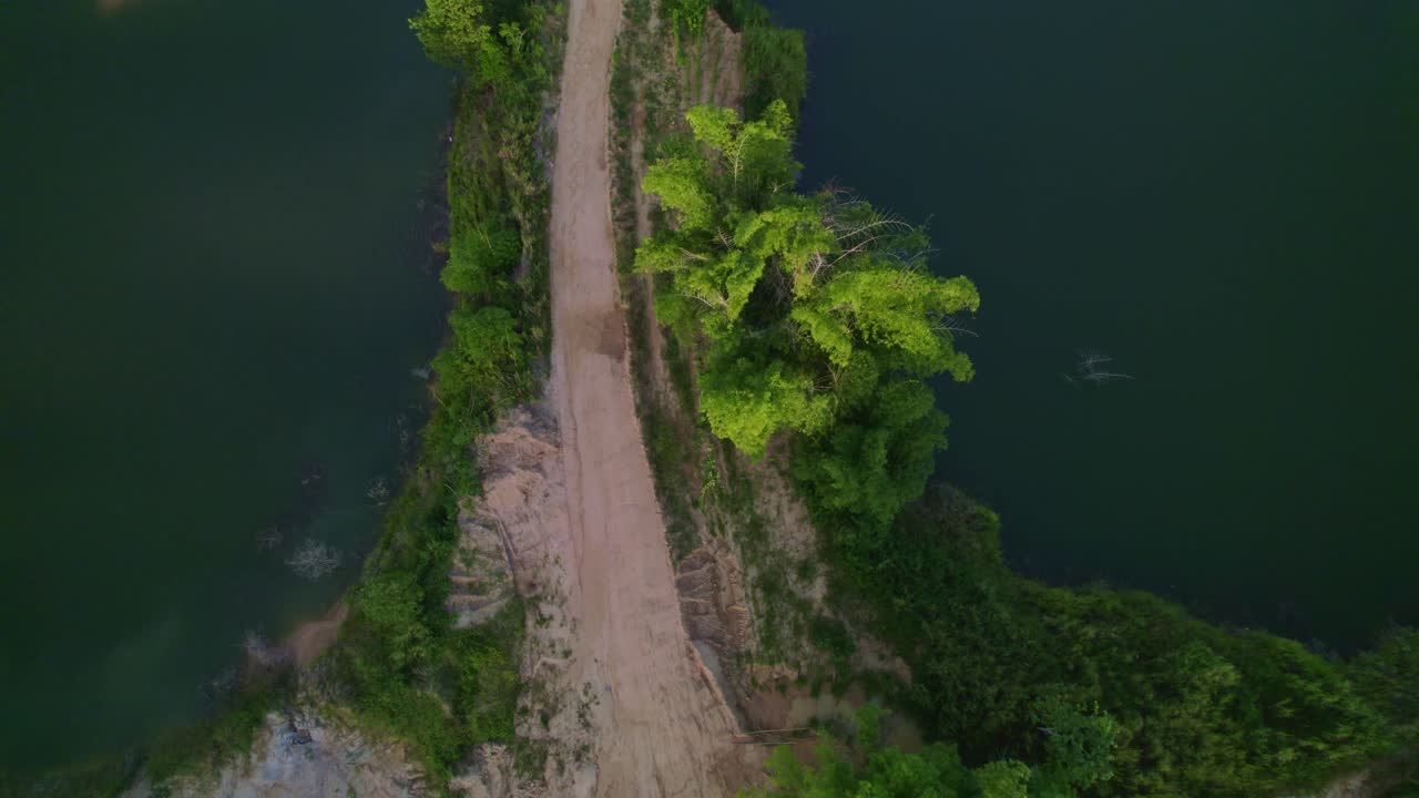 drone volando sobre un lago y un camino de tierra con un tracto