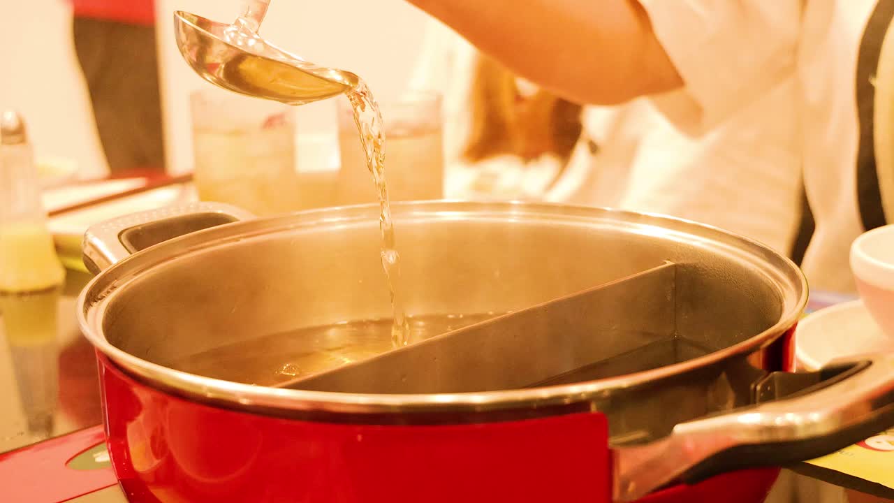 Chef prepares sukiyaki broth with ladle