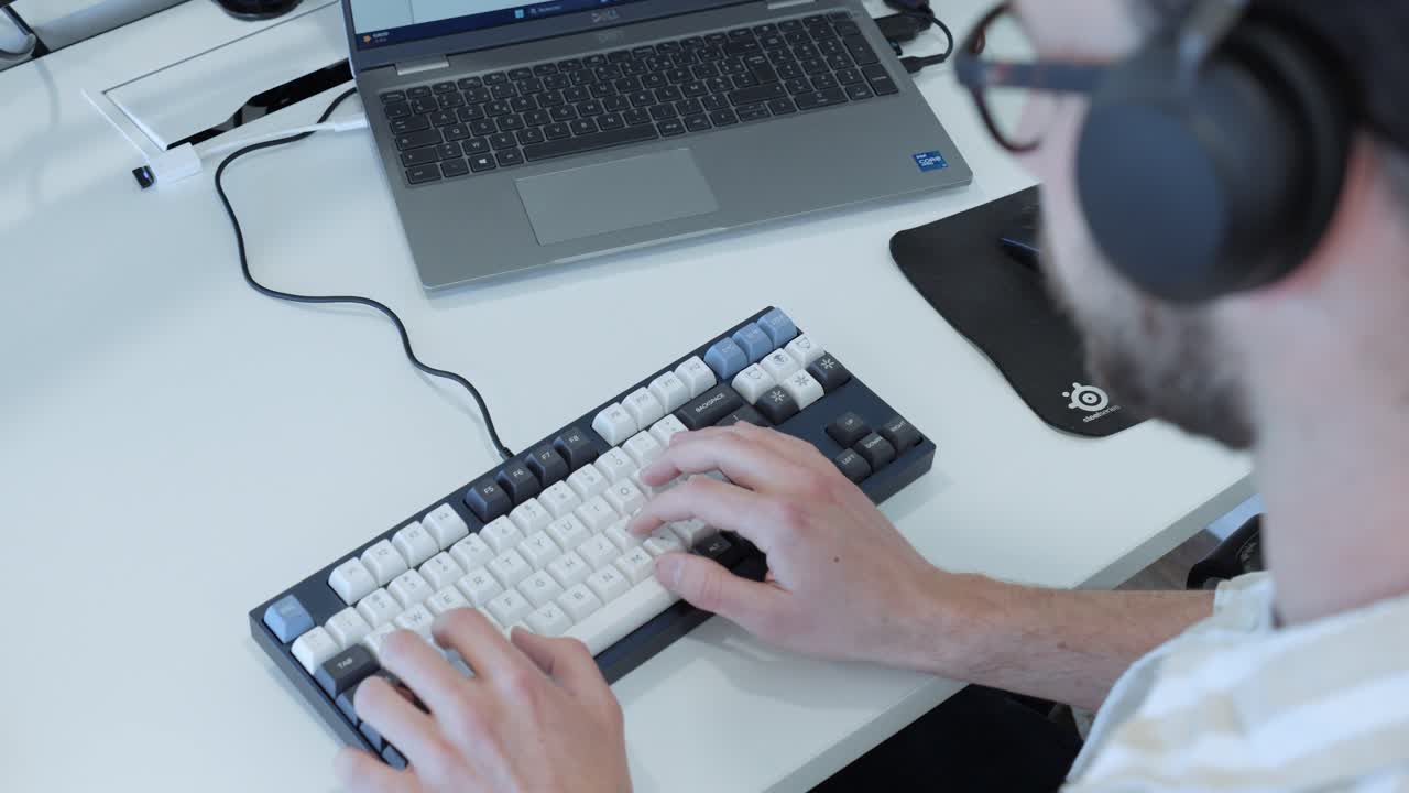 Person Typing on a Mechanical Keyboard at a Desk