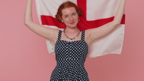 happy young woman waving british flag, looking smiling at camera, celebrating independence day