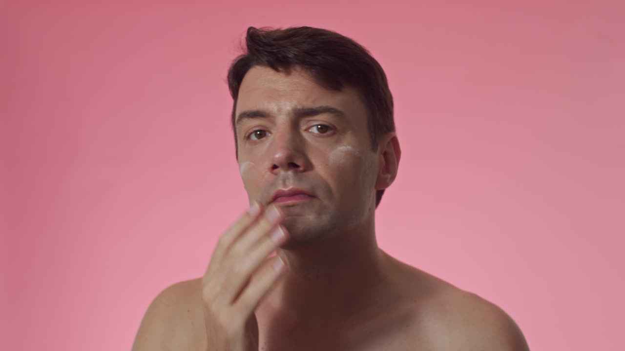 Male Millennial Applying Anti-wrinkle Cream on Face