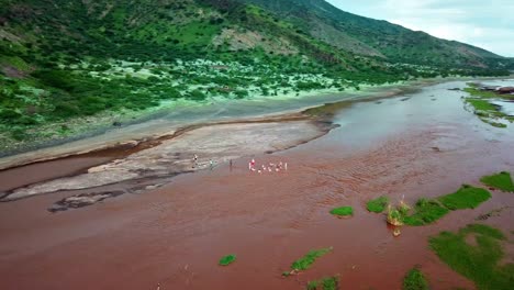 lago natron en tanzania con gente nadando en el agua - toma aérea de drones