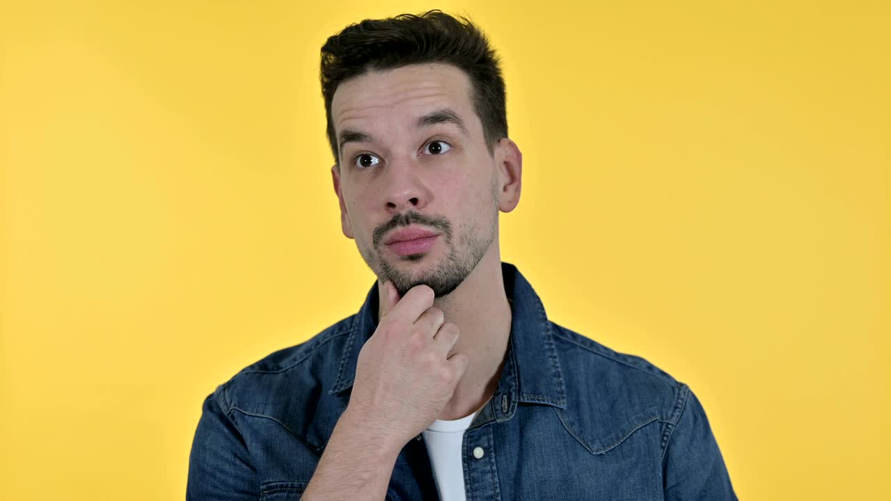 retrato de un joven atractivo pensando y obteniendo una idea, fondo amarillo