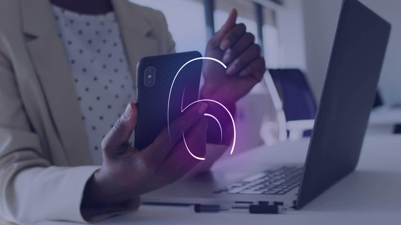 Animation of countdown over mid section of african american businesswoman using smartphone at office