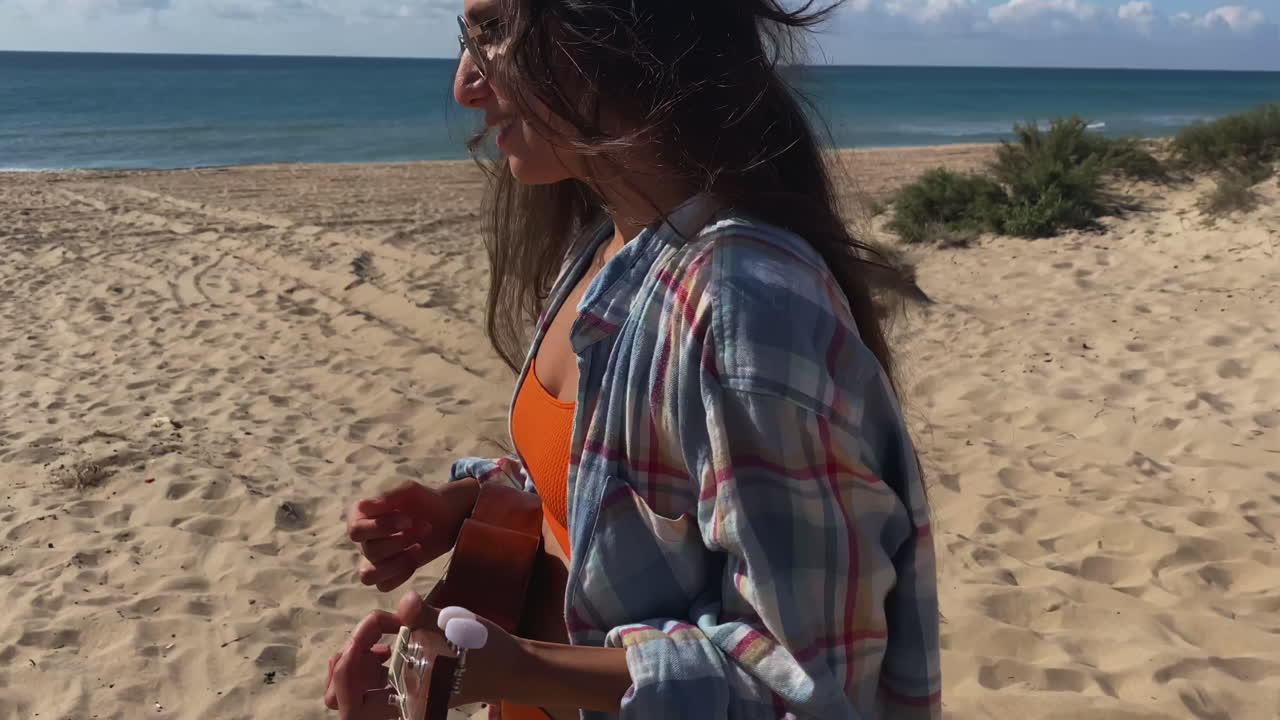 mujer tocando el ukulele en la playa